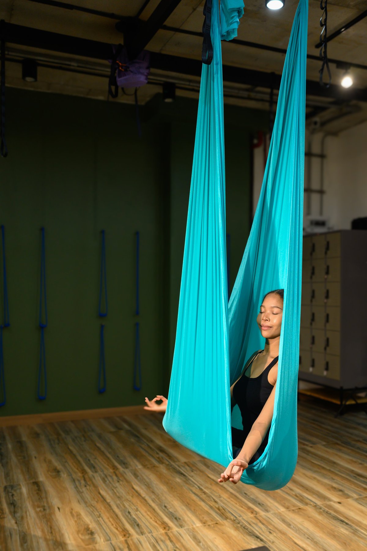 Serenity and calmness as a woman practices aerial yoga meditation