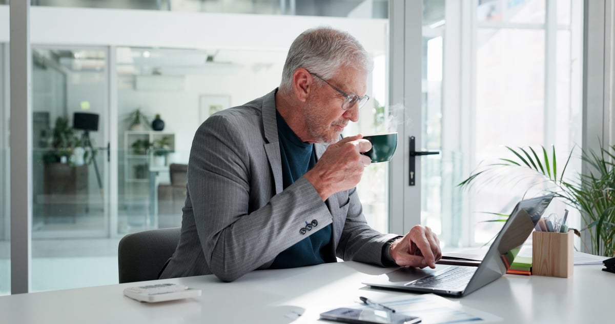 Office, coffee and man with laptop, typing and financial analysis on web, online and research on app. Business, accountant and mature person with tech for budget review, tea and planning for project