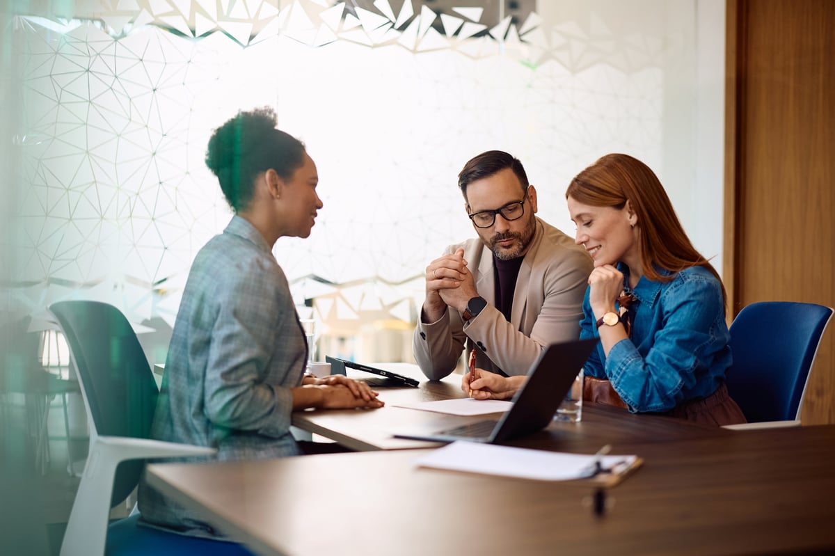 Smiling woman and her signing a contract with bank manager in the office